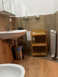 a bathroom with a sink and a toilet and a radiator at Monolocale Cerreto Laghi in Cerreto Laghi