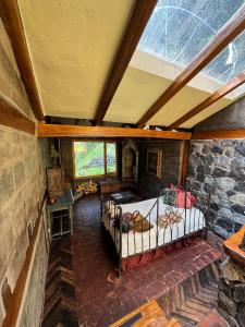 an attic room with a bed and a stone wall at Hacienda Rumiloma in Quito