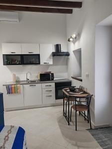 eine Küche mit einem Tisch und eine Küche mit weißen Schränken in der Unterkunft ManuIris in Butkovići