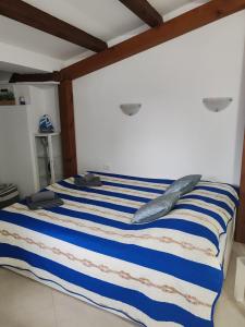 ein Bett mit blau-weiß gestreiften Laken und Kissen in der Unterkunft ManuIris in Butkovići