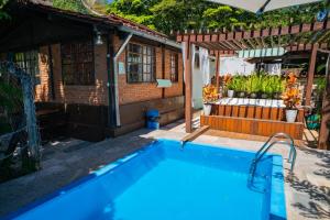 a swimming pool in front of a house at Pousada Aconchego in Pirenópolis