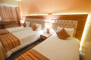 a hotel room with two beds and two lamps at Hotel Alles Blau in Pelotas +67 photos