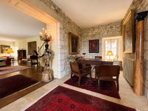 a living room with a table and chairs in it at Manoir Jorama - ancien musée de Joséphine Baker in Castelnaud La Chapelle