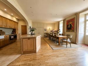 a kitchen and dining room with a table and chairs at Manoir Jorama - ancien musée de Joséphine Baker in Castelnaud La Chapelle