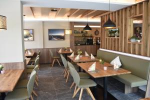 a restaurant with wooden tables and chairs at Hotel Kleißl in Oberperfuss