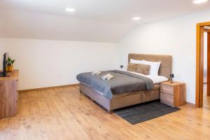 a bedroom with a bed and a wooden floor at Korana River Retreat with Sauna & Jacuzzi and View by Destination GREEN Croatia in Barilović