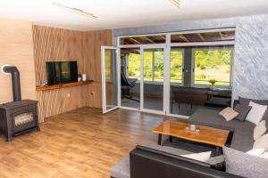 a living room with a couch and a fireplace at Korana River Retreat with Sauna & Jacuzzi and View by Destination GREEN Croatia in Barilović