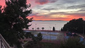 a sunset over a parking lot with a view of the water at Sea Breeze Retreat in Strožanac