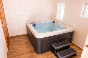a large bath tub with two steps in a bathroom at Korana River Retreat with Sauna & Jacuzzi and View by Destination GREEN Croatia in Barilović +29 photos
