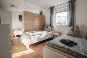 a bedroom with two beds and a window at Ferienwohnung Leipzig- Hirschfeld Apartments in Leipzig