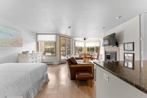 a bedroom with a bed and a desk and a kitchen at Lakeside #1496 in Keystone