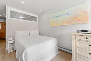 a white bedroom with a bed and a painting on the wall at Lakeside #1496 in Keystone +22 photos