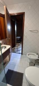a bathroom with a toilet and a sink at Hotel Domus Auditorium Suites in Villa Carlos Paz +22 photos