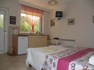 a room with two beds and a kitchen with a window at Villa Verde Apart-Hotel in Nea Makri