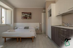 a small bedroom with a bed and a sink at Hotiday Trieste Corso Italia in Trieste