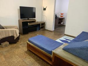 a living room with two beds and a flat screen tv at Casa na praia bem localizada in Marataizes