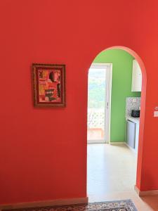 a kitchen with a red wall with a picture on it at Art & Motion Union - Guest Room 5 in Andros