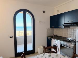 a kitchen with a window with a view of the beach at Appartamenti Lungomare Via Roma in Castiglione della Pescaia