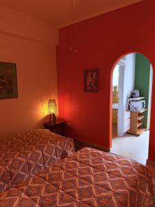 a bedroom with a bed and a red wall at Art & Motion Union - Guest Room 5 in Andros