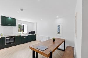 a kitchen with green cabinets and a wooden table at Flour Mill House - Pitkerro Mill in Dundee
