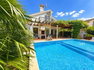 a swimming pool in front of a house at Villa Magnetic in Baošići