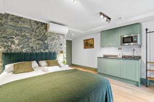 a bedroom with a green bed and a kitchen at Upper Victoria in London