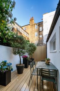 a patio with a table and chairs on a deck at Upper Victoria in London