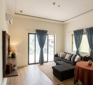 a living room with a black couch and blue curtains at M Residence in Accra