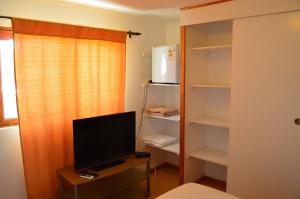 a bedroom with a tv and a desk with a computer at Hotel Observatorio TukunMapu in Vicuña