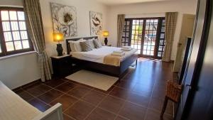 a bedroom with a bed with two lamps and two windows at Casa Grande Holidays in São Martinho do Porto +81 photos