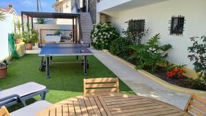 a ping pong table in the middle of a garden at Casa Grande Holidays in São Martinho do Porto