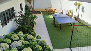a ping pong table in a room with plants at Casa Grande Holidays in São Martinho do Porto