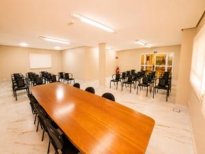 ein Konferenzraum mit einem großen Holztisch und Stühlen in der Unterkunft Hotel Riviera Lins in Lins + 32 Fotos