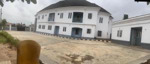 a large white building with a black roof at House One Apartment in Akure