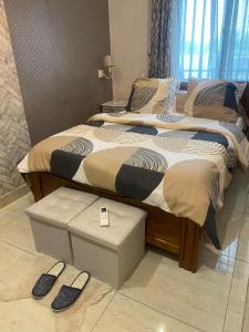 a bedroom with two beds with slippers on the floor at La Bienveillance in Brazzaville +3 photos