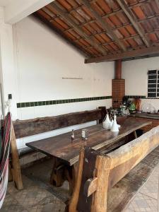 a large wooden table in a room with a kitchen at Quarto para viajantes in Montes Claros