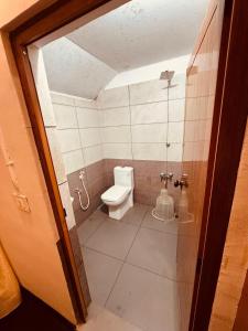 a small bathroom with a toilet and a shower at Padmalayam Heritage Villa in Mānantoddy +40 photos