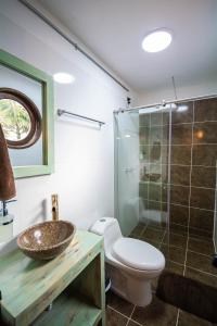 a bathroom with a toilet and a sink and a shower at Hotel Alto lindo in Guatapé +108 photos