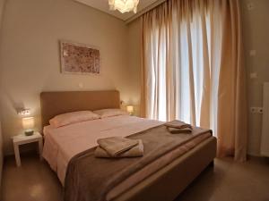 a bedroom with a large bed with two towels on it at Anelia in Nea Artaki