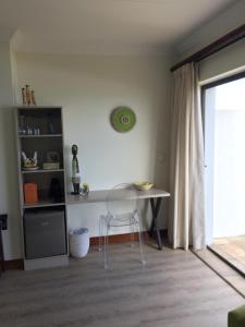 a table and chair in a room with a window at Classical View Guesthouse in Mossel Bay
