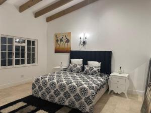 a bedroom with a bed with a black and white comforter at yalwa house in Sweet Valley