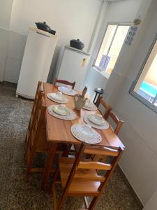 a wooden table with plates on it in a room at Casa na praia bem localizada in Marataizes
