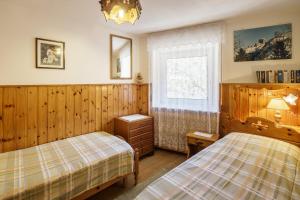 a bedroom with two beds and a window at CiasaToa in Cortina dʼAmpezzo