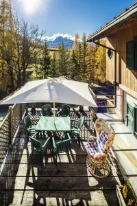 a patio with a table and chairs and an umbrella at CiasaToa in Cortina dʼAmpezzo