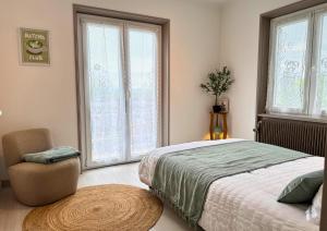 a bedroom with a bed and a chair and windows at VILLA LÉMAN - Panoramic lake view in Évian-les-Bains