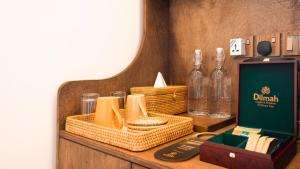 a table with baskets and bottles on a shelf at Villa Lumora Maldives in Rasdhoo