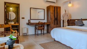 a bedroom with a bed and a bathroom with a sink at Villa Lumora Maldives in Rasdhoo