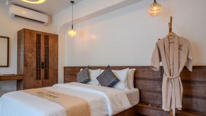 a bedroom with a large bed with a wooden headboard at Villa Lumora Maldives in Rasdhoo
