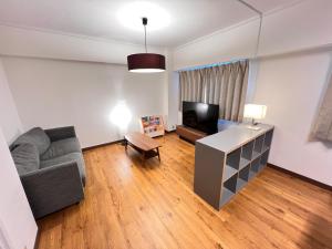 a living room with a couch and a tv at 北浜703 3ベッドルーム貸切 高松港近く 最大6名 in Takamatsu