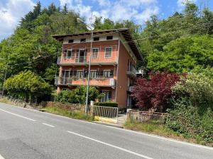 ein orangefarbenes Gebäude am Straßenrand in der Unterkunft Giulia Cottage in Strona
